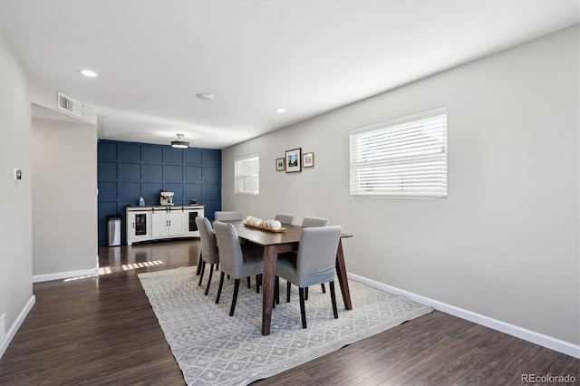 dining space featuring dark wood-style floors, baseboards, and visible vents