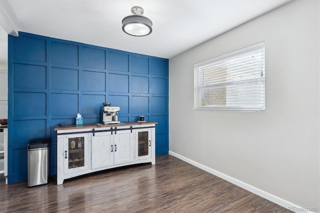 bar with dark wood-style floors, beverage cooler, baseboards, and a decorative wall