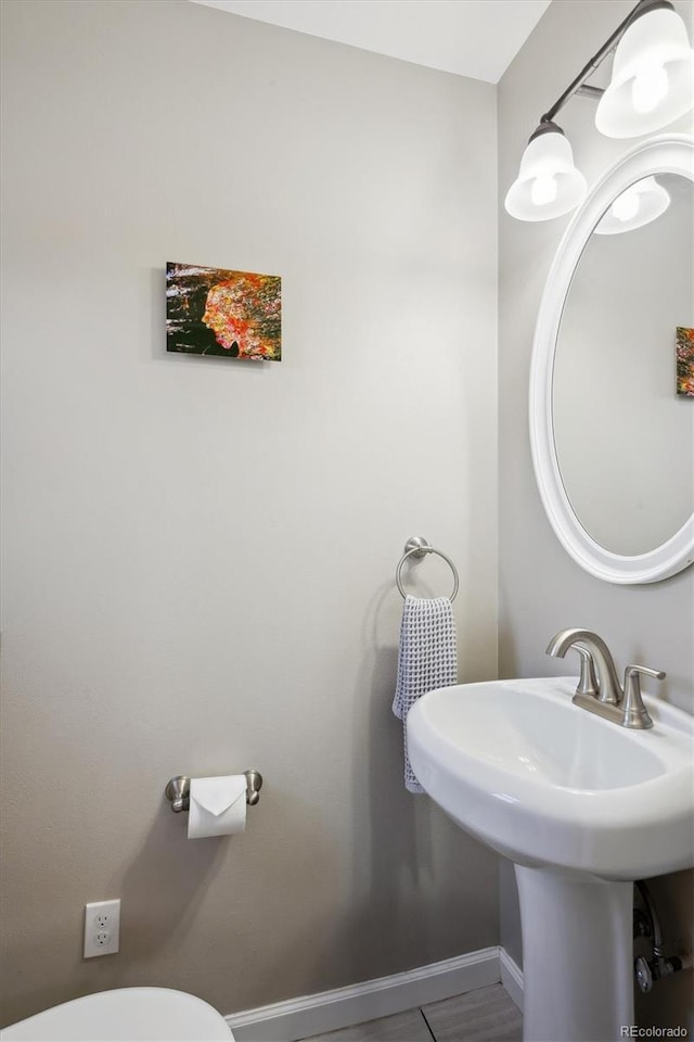 bathroom with toilet and baseboards