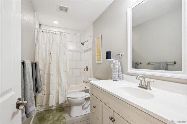 bathroom featuring toilet, shower / bath combo with shower curtain, vanity, and visible vents