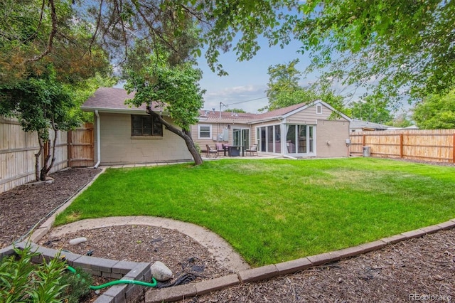 rear view of house with a patio area, a fenced backyard, and a yard