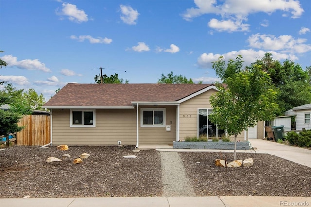 ranch-style home featuring driveway and fence