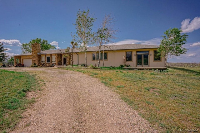 ranch-style home with a garage and a front lawn