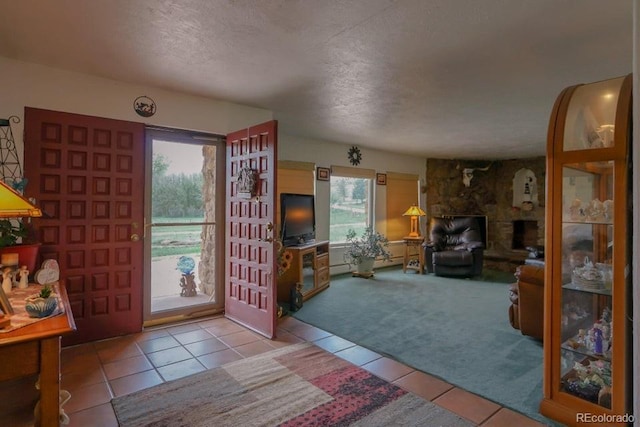 carpeted living room with a textured ceiling, a fireplace, and a wealth of natural light