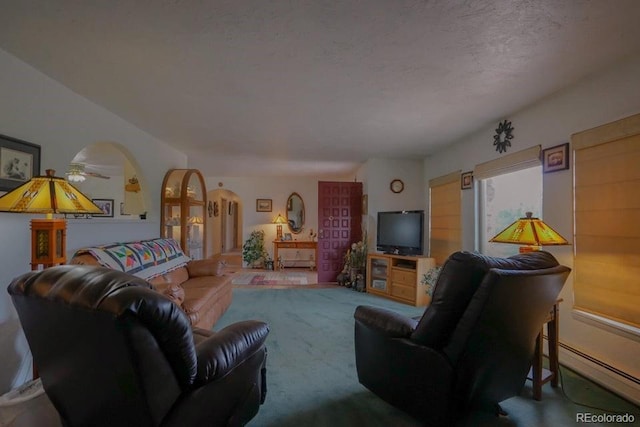 living room featuring a textured ceiling, baseboard heating, and ceiling fan