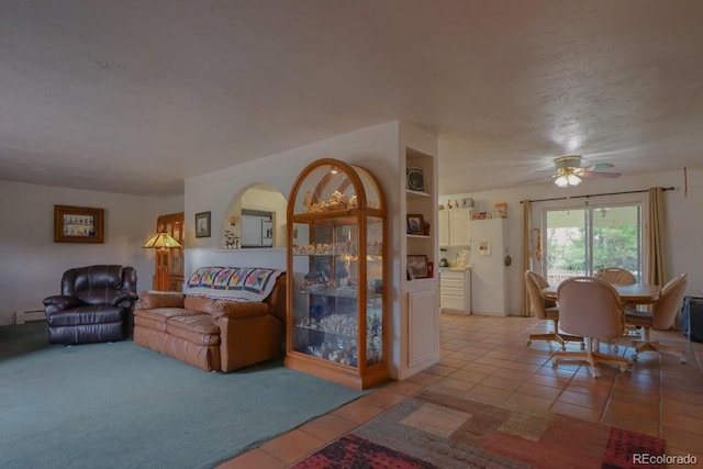 tiled living room featuring ceiling fan, a textured ceiling, and a baseboard heating unit