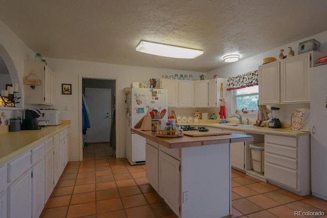 kitchen with white cabinets, white fridge, and a kitchen island