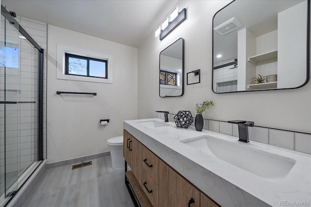 bathroom featuring toilet, vanity, and walk in shower