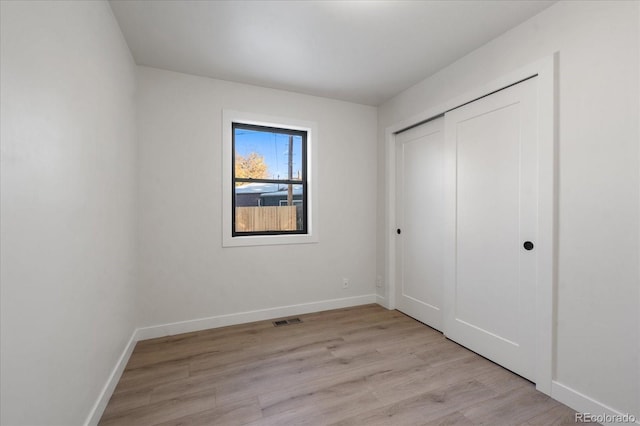 unfurnished bedroom with a closet and light hardwood / wood-style flooring