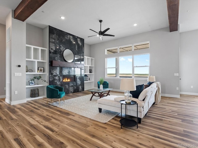 62101 E 32nd Ct, Strasburg, CO 80136 - living area featuring baseboards, recessed lighting, wood finished floors, ceiling fan, and a tiled fireplace