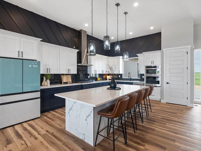 62101 E 32nd Ct, Strasburg, CO 80136 - kitchen featuring appliances with stainless steel finishes, tasteful backsplash, wood finished floors, a center island, and recessed lighting