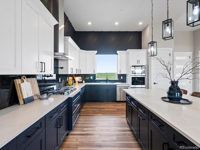 62101 E 32nd Ct, Strasburg, CO 80136 - kitchen with appliances with stainless steel finishes, a sink, light wood-style flooring, white cabinetry, and backsplash