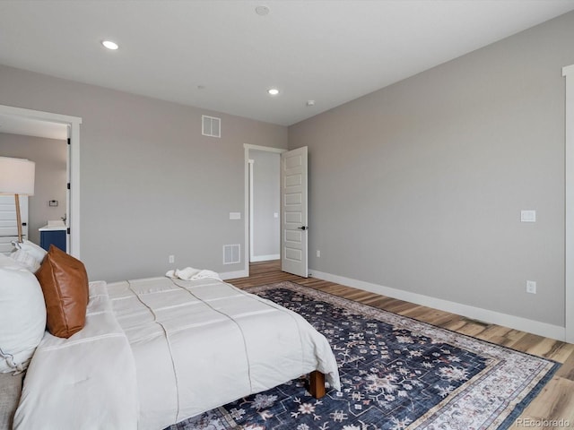62101 E 32nd Ct, Strasburg, CO 80136 - bedroom with baseboards, wood finished floors, recessed lighting, and ensuite bathroom