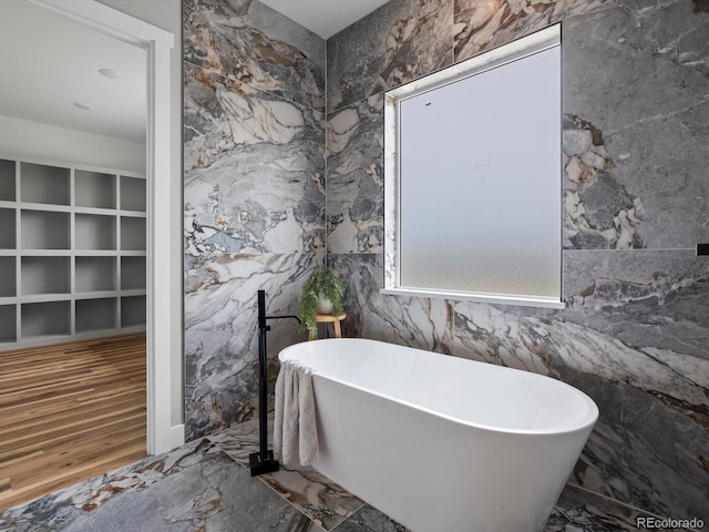 62101 E 32nd Ct, Strasburg, CO 80136 - full bathroom with a soaking tub and marble tiled flooring