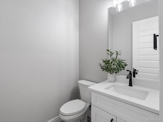62101 E 32nd Ct, Strasburg, CO 80136 - bathroom with vanity, toilet, and a textured wall