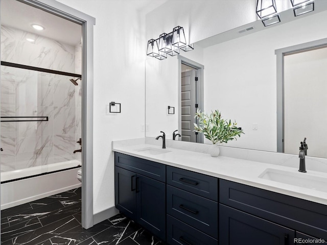 62101 E 32nd Ct, Strasburg, CO 80136 - full bathroom with marble look tile flooring, double vanity, toilet, baseboards, and bath / shower combo with glass door