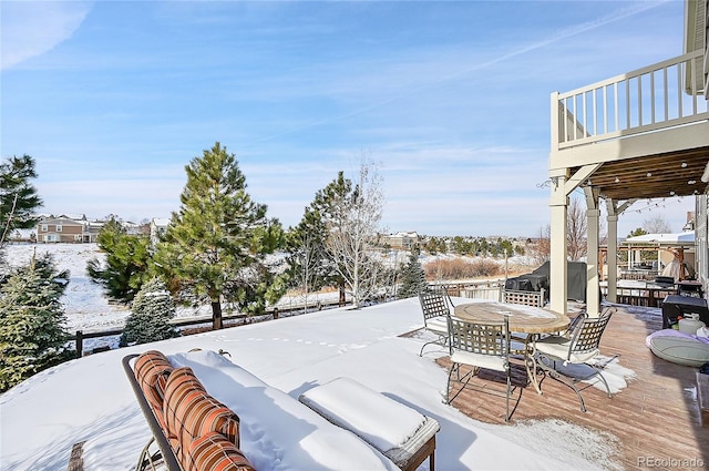 snow covered patio featuring a balcony, a grill, and a deck