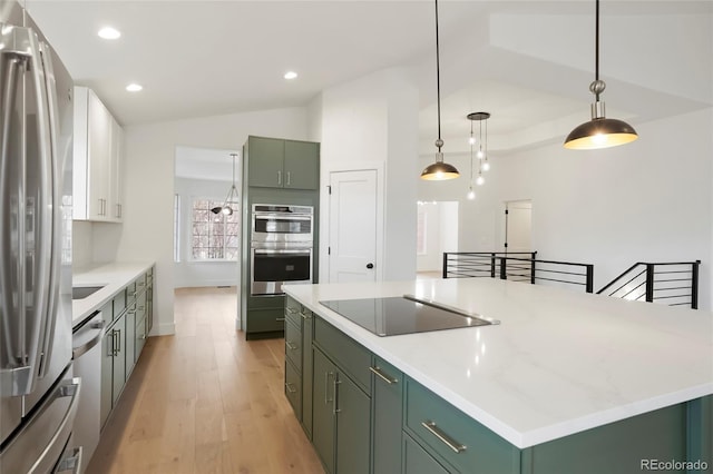 kitchen with pendant lighting, stainless steel appliances, green cabinetry, and a kitchen island