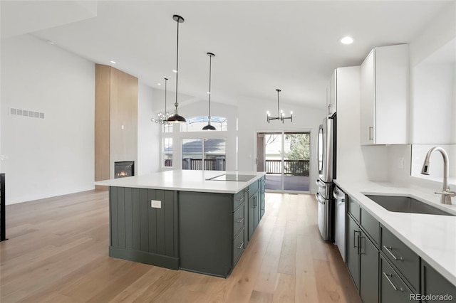 kitchen with white cabinetry, sink, hanging light fixtures, a center island, and stainless steel appliances