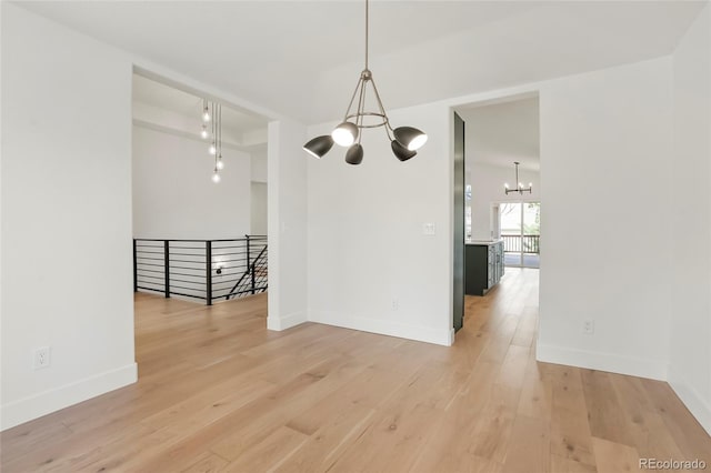 unfurnished dining area featuring a chandelier and hardwood / wood-style floors