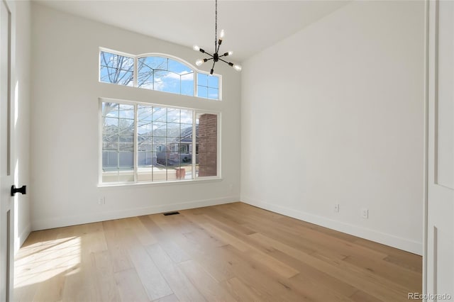 interior space featuring a high ceiling, a chandelier, and light hardwood / wood-style floors