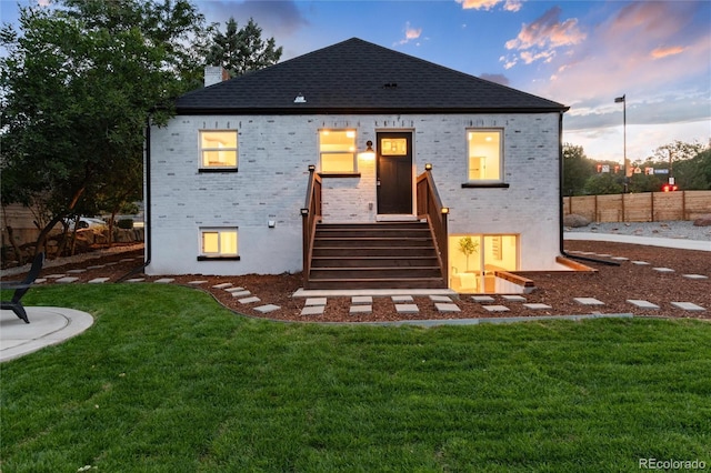 back house at dusk with a yard