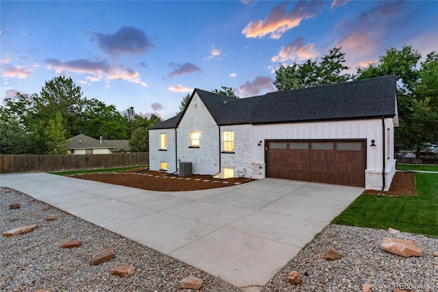 modern farmhouse featuring a garage and central air condition unit