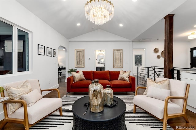 living room with lofted ceiling, hardwood / wood-style flooring, and a chandelier