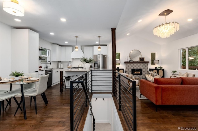 interior space featuring premium range hood, stainless steel fridge, dishwasher, and hanging light fixtures