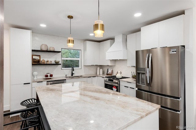 kitchen featuring premium range hood, sink, white cabinets, stainless steel appliances, and light stone countertops