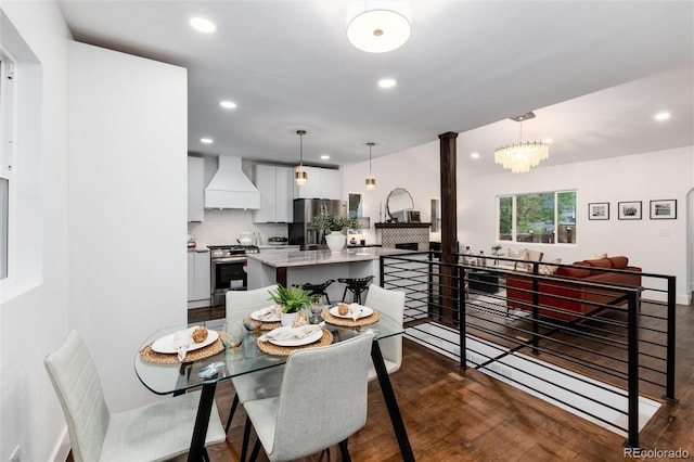 dining area featuring dark wood-type flooring and a chandelier