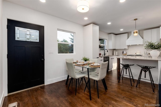 dining space with dark hardwood / wood-style flooring and sink