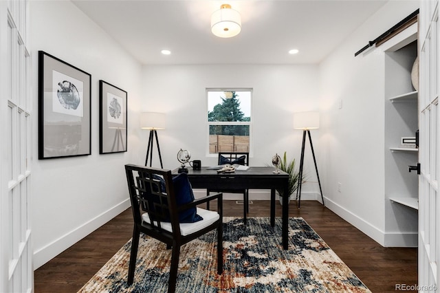 office space with dark hardwood / wood-style flooring and a barn door