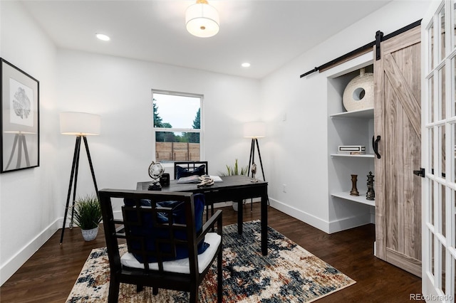 office featuring a barn door and dark hardwood / wood-style floors