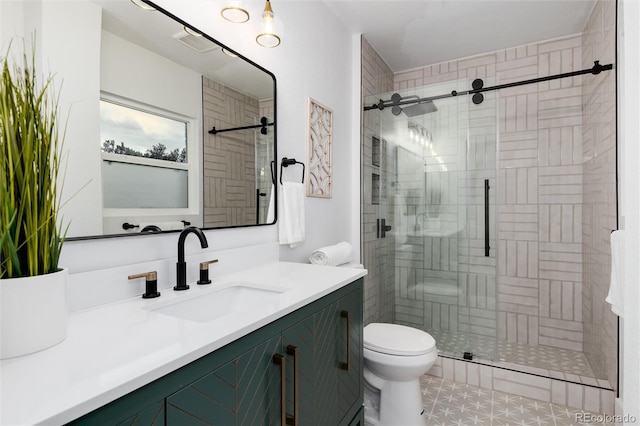 bathroom with vanity, toilet, and a shower with door