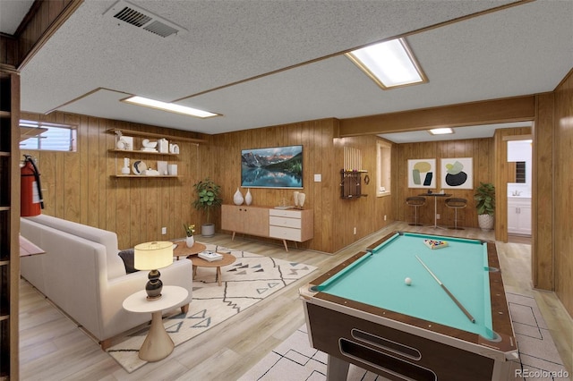 rec room featuring pool table, a textured ceiling, and wood walls