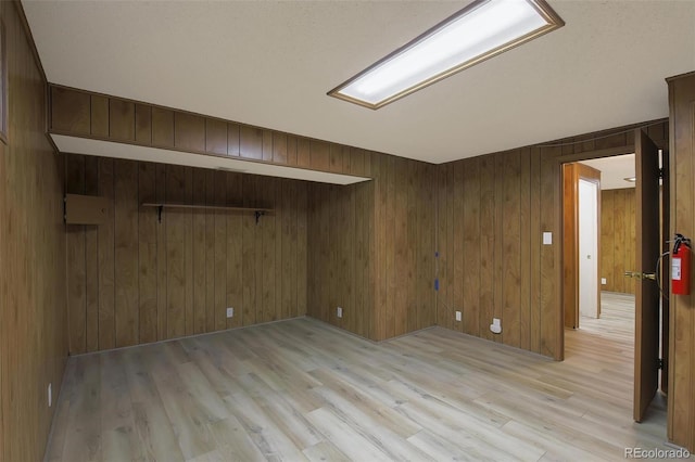 spare room with wooden walls and light hardwood / wood-style floors