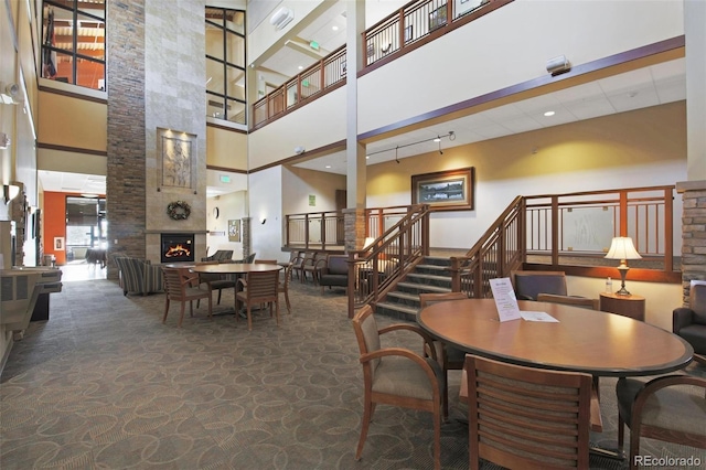 dining space with a large fireplace and a high ceiling