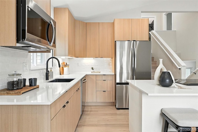 11635 W Security Ave, Lakewood, CO 80401 - kitchen with appliances with stainless steel finishes, light brown cabinets, modern cabinets, light wood-style flooring, and vaulted ceiling