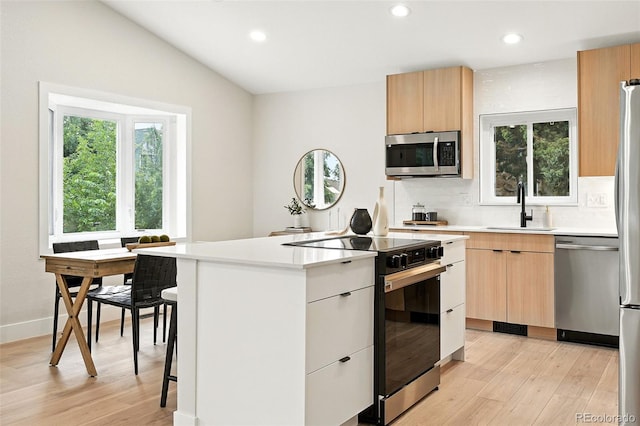 11635 W Security Ave, Lakewood, CO 80401 - kitchen featuring stainless steel appliances, light wood finished floors, modern cabinets, light countertops, and tasteful backsplash
