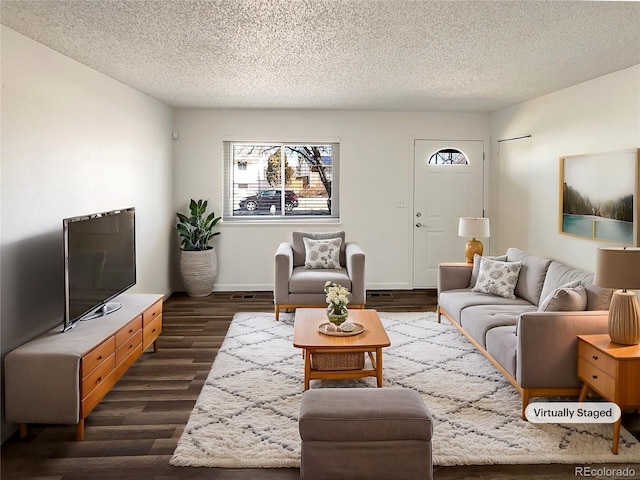 living room with dark wood-type flooring, a textured ceiling, and baseboards