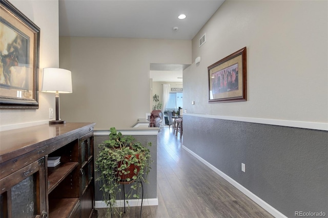 hall featuring visible vents, recessed lighting, and dark wood-style flooring
