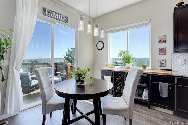 dining space featuring plenty of natural light, light wood-type flooring, and visible vents