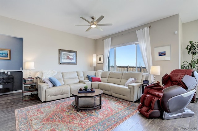 living area with baseboards, a ceiling fan, and wood finished floors