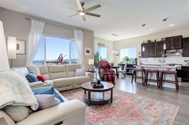 living room with recessed lighting, ceiling fan, and light wood-type flooring