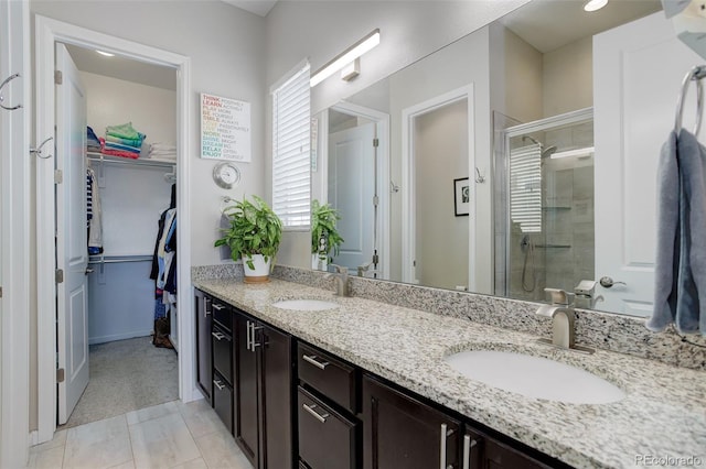 full bath featuring a sink, a walk in closet, and a stall shower