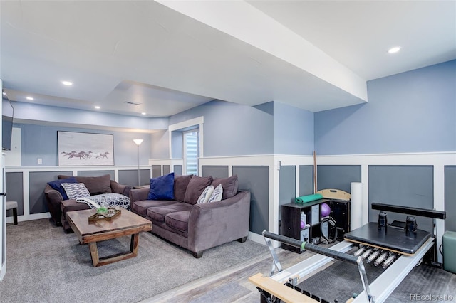 living area with recessed lighting, wainscoting, and a decorative wall