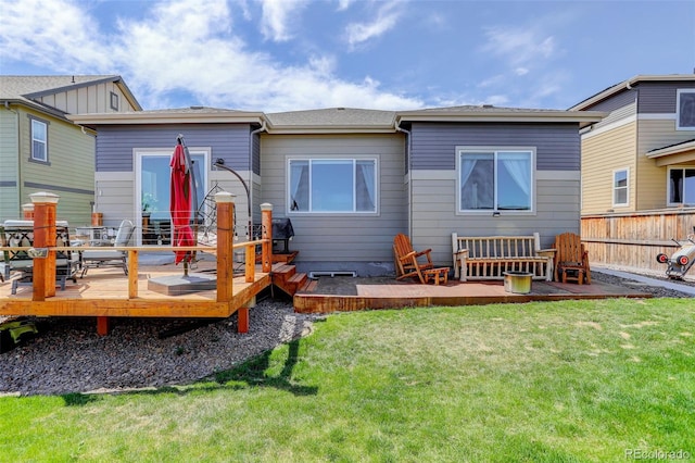 rear view of property with a lawn, fence, and a wooden deck