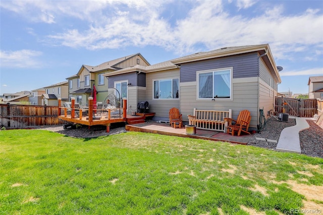 back of property featuring a lawn, a wooden deck, a fenced backyard, and central air condition unit