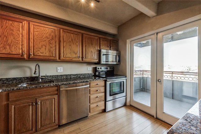 kitchen with light wood-style flooring, french doors, stainless steel appliances, and a sink